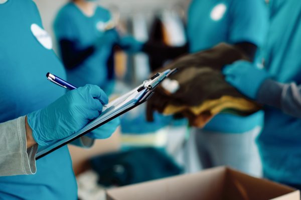 Close-up of a volunteer going through checklist while working in charitable foundation.